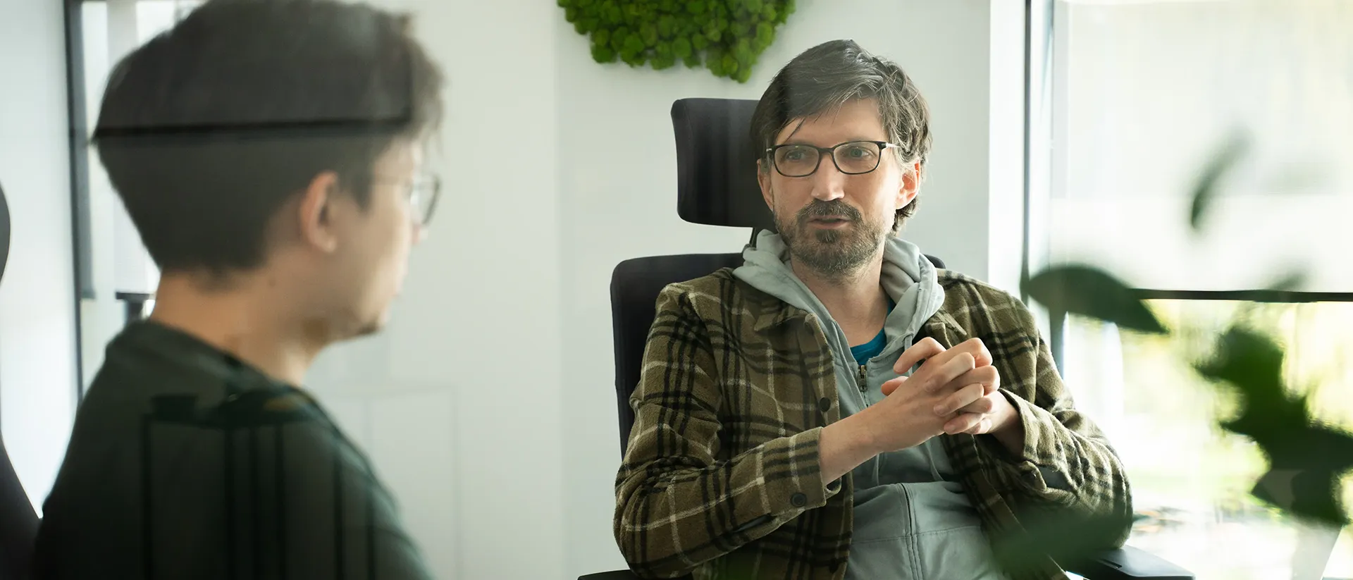 A data professional with headphones working at a computer in the office.